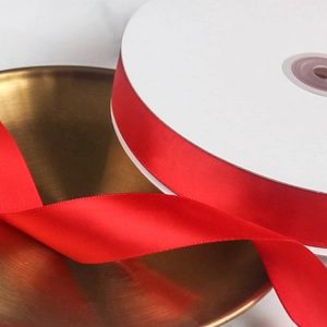 Macro detail of vibrant red satin ribbon roll for wedding decor and gift wrapping