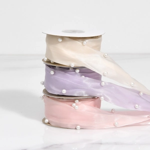 Close-up of pastel chiffon ribbons with delicate white pearl edges for DIY crafts