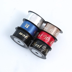 Rolls of assorted satin ribbons with gold foil lettering for gift and floral packaging
