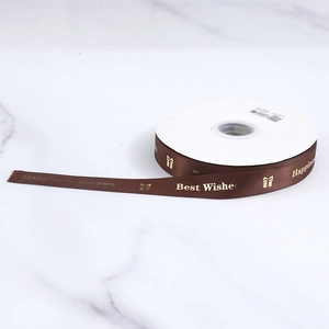 Macro view of brown satin ribbon with gold foil Happiness for you printed text
