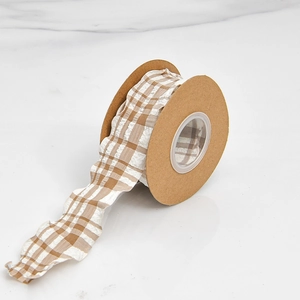 Detailopname van beige geruit geplooid lint met golvende textuur op een kraft spoel