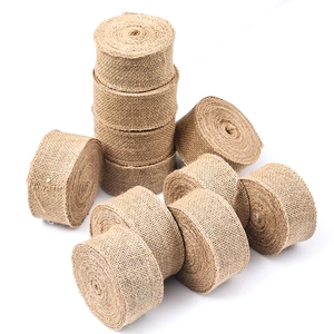 Macro detail of natural burlap ribbon rolls showing rustic jute fiber texture and weave