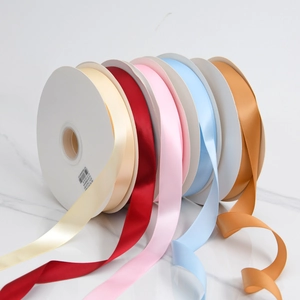 Detailed view of 2cm colorful high-density polyester satin ribbons on rolls for gift packing