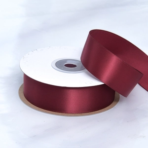 Detailed view of burgundy double-sided polyester satin ribbon roll for gift wrapping