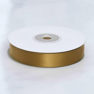Close-up of golden satin polyester ribbon roll on white spool for gift packaging