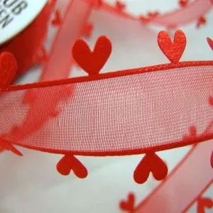 Gros plan sur un ruban en maille rouge transparent avec bords décoratifs en forme de cœur 3D