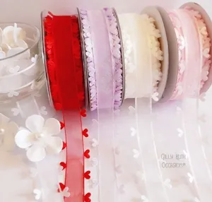 Détail de rubans en organza transparent de 2,5 cm avec bordure en cœur en quatre coloris