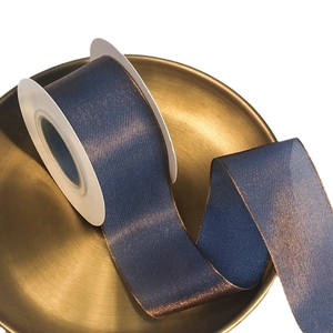 Deep indigo chameleon silk ribbon with bronze metallic sheen on a gold tray