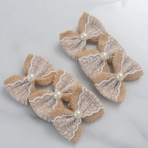 Detail of 6pcs burlap bow hair clips with white lace and pearl on marble background
