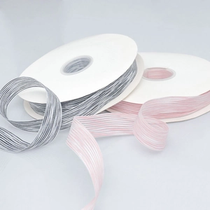 Close-up of multicolored striped polyester ribbons on spools for gift wrapping and hair crafts