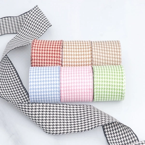 Detailed macro view of 4cm wide houndstooth ribbon rolls in multiple colors for DIY crafts