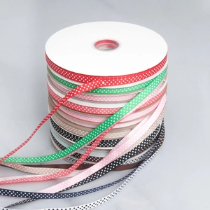 Close-up of assorted 2.5cm polka dot grosgrain ribbons in vibrant colors for DIY crafts
