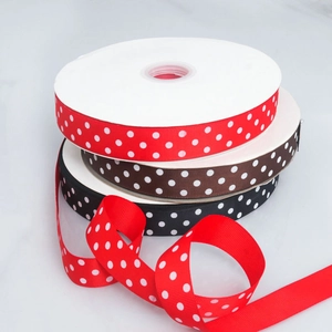 Close-up of 2.5cm polka dot grosgrain ribbons in red, black, and brown for DIY crafts