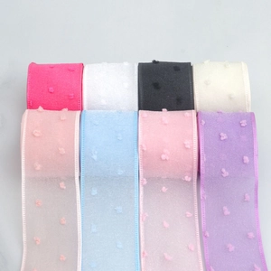 Macro detail of 4cm transparent organza ribbon with 3D pom-pom trim in multiple colors