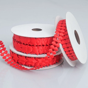 Close-up of red heart-shaped satin ribbon on rolls for Valentine gift wrapping and DIY crafts