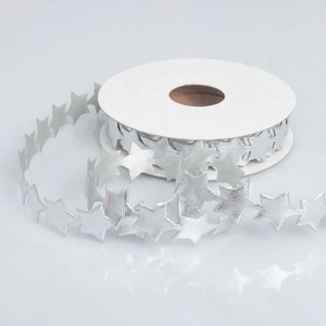 Close-up of star-shaped silver metallic lace ribbon on a white cardboard spool roll