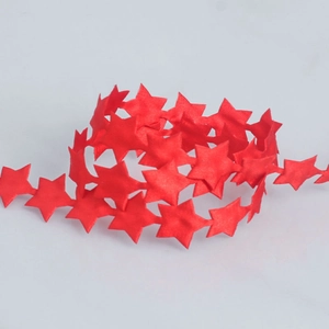 Macro detail of red star-shaped polyester ribbon for festive gift wrapping and decoration