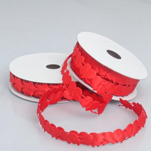 Close-up of red heart-shaped polyester ribbon rolls for Valentine gift wrapping and DIY crafts
