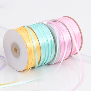 Detailed view of colorful 3mm polyester satin ribbon rolls for DIY crafts and gift wrapping