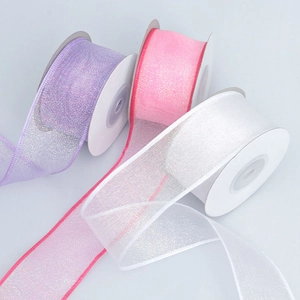 Close-up of colorful iridescent organza ribbons with fine glitter on white spools
