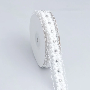 Close-up of white lace ribbon with silver beads for DIY hair bows and gift wrapping