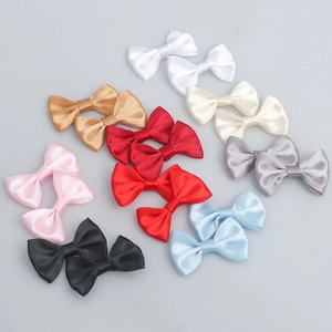 Detailed flat lay of colorful 2.5x4cm polyester satin bows for DIY crafts and accessories