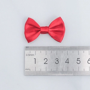 Red polyester satin ribbon bow measured with a ruler for DIY crafts and gift packaging
