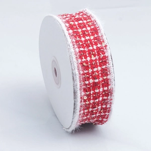 Detail of red tweed ribbon with gold sequins and white faux fur trim on a spool