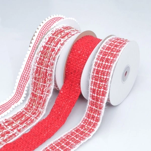 Close-up of red plaid and tweed ribbons with sequins on spools for DIY hair accessories