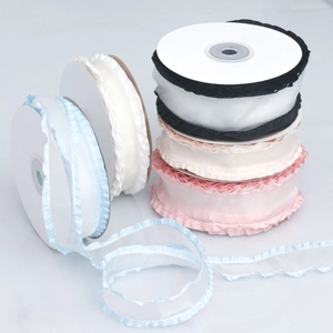 Close-up of assorted ruffled organza ribbons in various colors on white plastic spools
