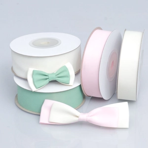 Rolls of matte polyester ribbons with handmade bows in pastel green, pink, and cream white