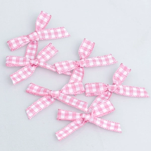 Detailed macro view of pink and white plaid bows made of textured fabric ribbon
