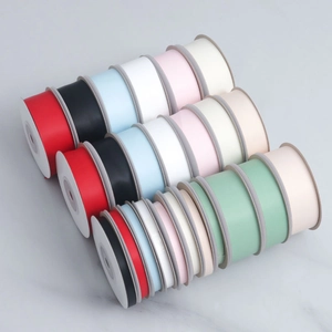 Assorted colors and widths of double-sided matte satin ribbons on white plastic spools