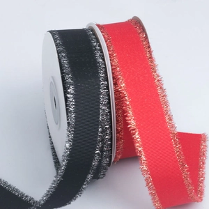 Detail of red and black ribbed ribbon rolls with metallic gold and silver fringe edges