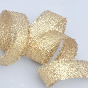 Sparkling gold metallic fringe ribbon with frayed edges for gift wrapping and wedding decor