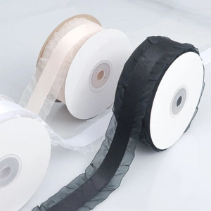 Detailed view of pleated organza ribbons in black and cream for DIY crafts and gift wrapping