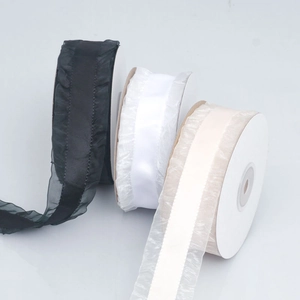 Close-up of pleated organza ribbon rolls in black and white for DIY hair accessories