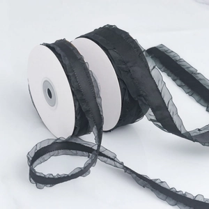 Detail of black pleated chiffon ribbon on a white spool for gift wrapping and DIY crafts