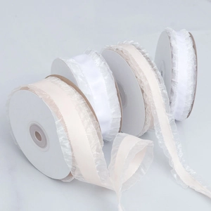 White and beige ruffled satin ribbons in rolls for wedding decor and handmade crafts