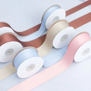 Macro view of assorted matte satin ribbons in muted tones for elegant gift packaging