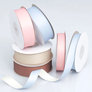 Rolls of matte polyester cotton ribbons in pink, blue, champagne and brown for gift wrapping