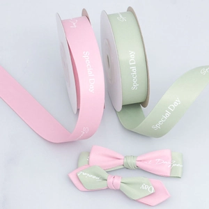 Detail of pink and green 'Special Day' polyester ribbons with a handmade bow for DIY gift wrapping