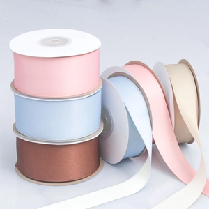 Detailed view of matte cotton-polyester ribbons on spools in pastel and neutral tones
