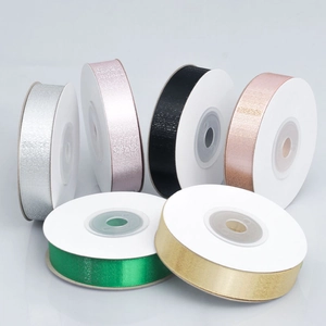 Close-up of metallic gradient ribbons in gold and silver for gift box packaging decor