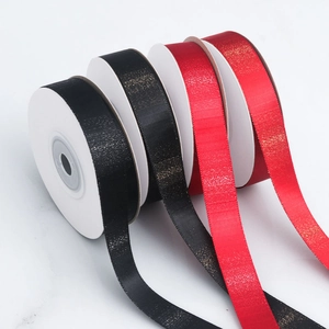 Detail view of shimmering polyester gradient ribbons with metallic gold and silver glitter texture