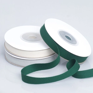 Close-up of herringbone cotton webbing tapes in dark green, beige, and light gray colors