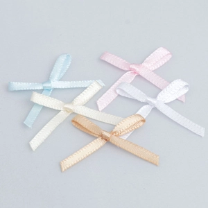 Detailed macro view of assorted mini polyester satin bows in five soft pastel colors