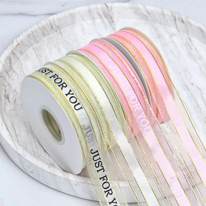 Detailed view of ribbons with gold edges and Just For You text on marble plate