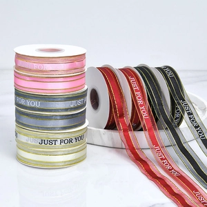 Macro shot of colorful satin ribbons with gold edges and Just For You printed text