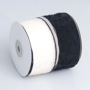 Detail of dual-color black and white plush fringe ribbon on spools for DIY gift packaging